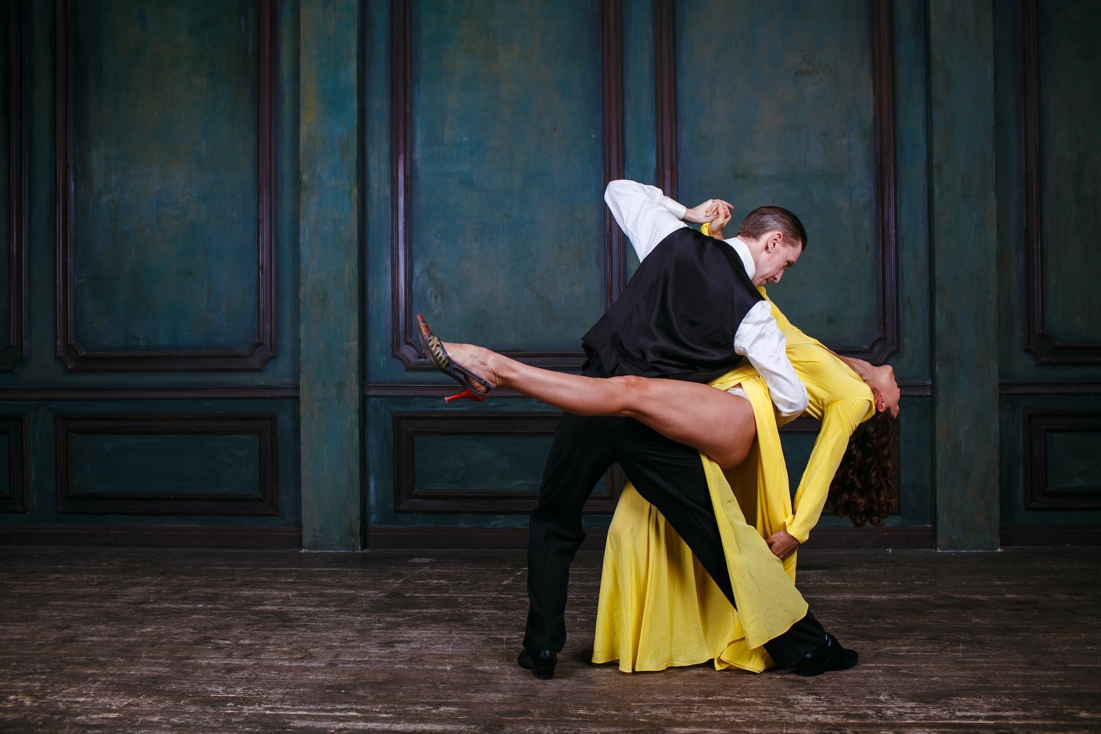 Man and woman in black dress dance tango